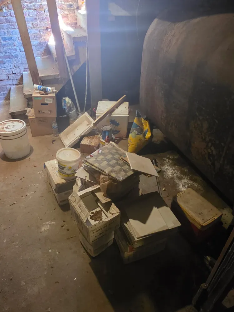Before: basement corner cleared around the oil tank — Pioneer Valley Junk Removal job