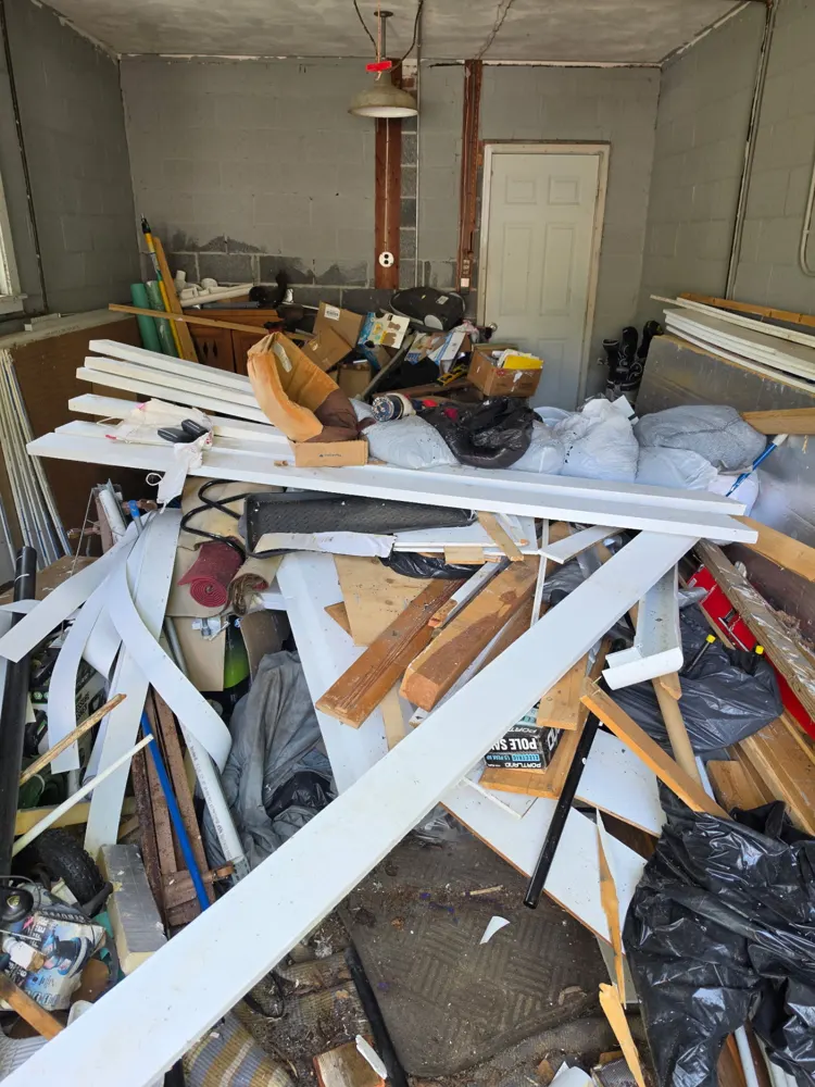 Before: garage packed with scrap lumber, cleared — Pioneer Valley Junk Removal job
