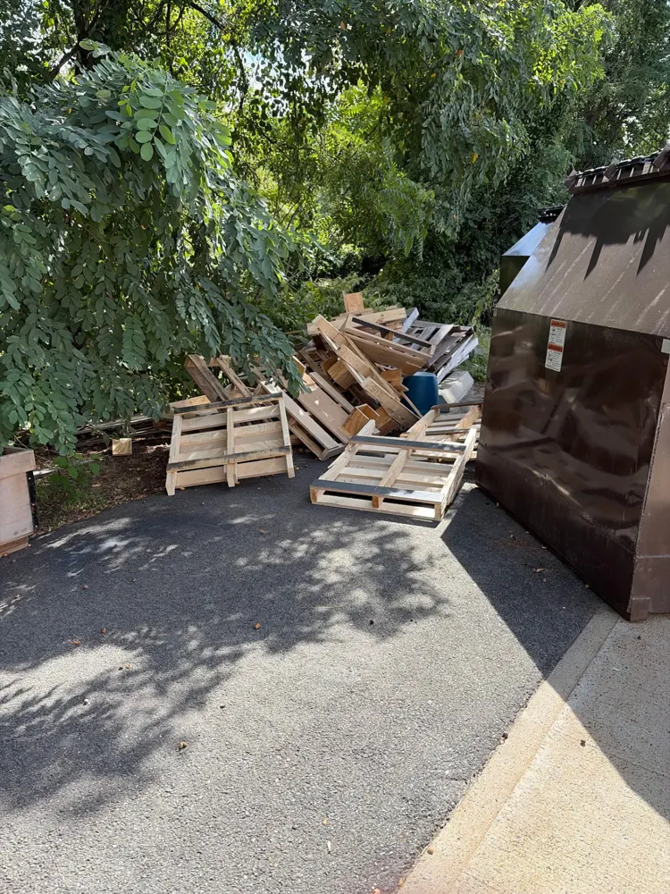 Before: wood pallets stacked outside a charter school cleanout — Pioneer Valley Junk Removal job