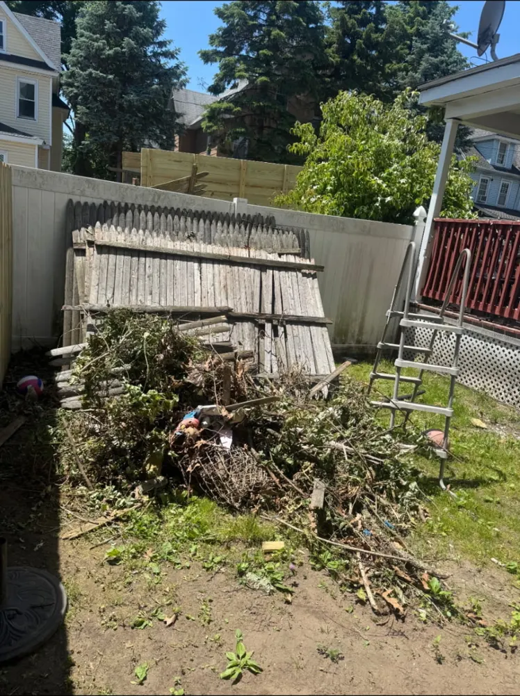 Before: backyard debris pile cleared — Pioneer Valley Junk Removal job