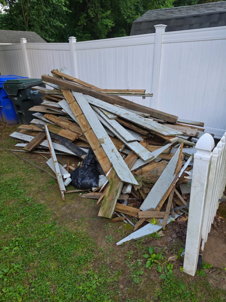 Before: pile of old lumber removed from the yard — Pioneer Valley Junk Removal job